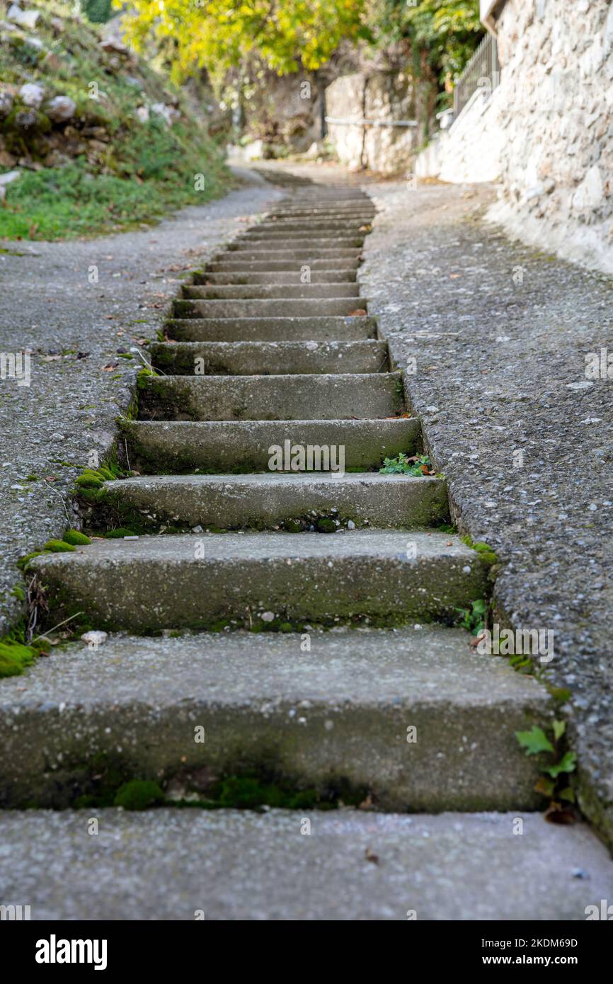 Passo dopo passo per raggiungere la parte superiore. Scalinata stretta con direzione in alto, scala in cemento escursionismo in natura. Verticale Foto Stock