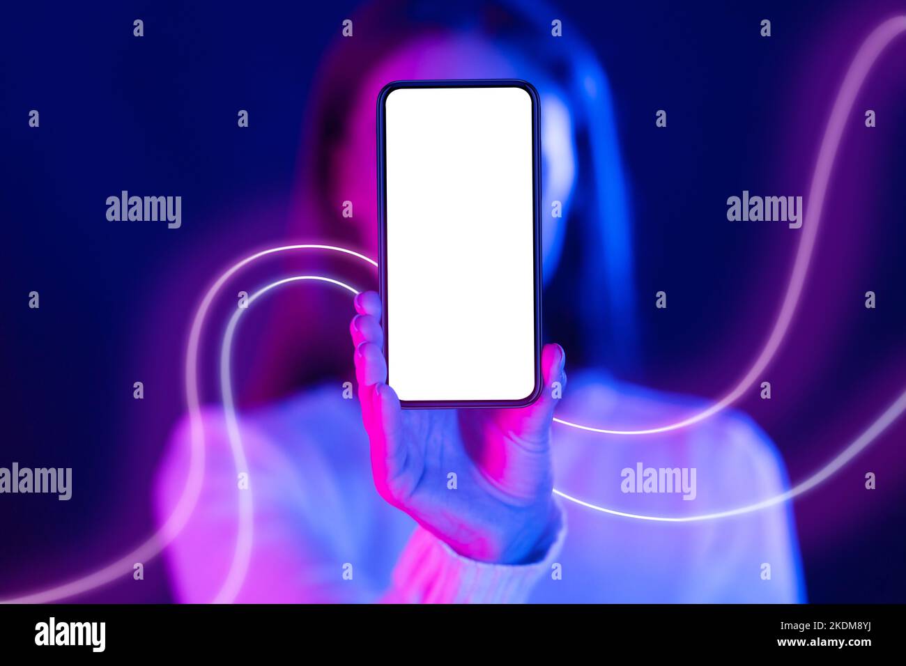 Donna irriconoscibile che si nasconde dietro il telefono cellulare con schermo vuoto, mockup Foto Stock