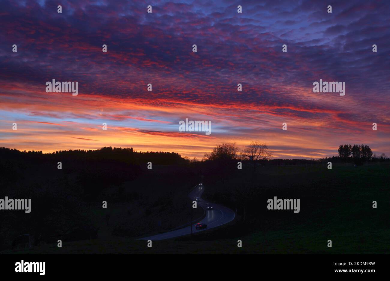 Kaufbeuren, Germania. 07th Nov 2022. Le auto guidano sotto il cielo colorato dal sole di tramonto. Credit: Karl-Josef Hildenbrand/dpa/Alamy Live News Foto Stock