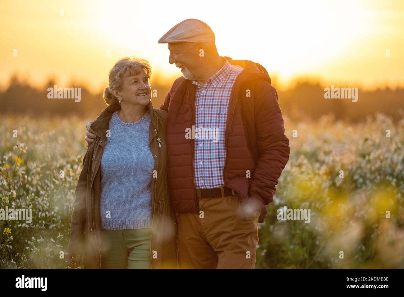 Coppia anziana in un campo in autunno al tramonto Foto Stock