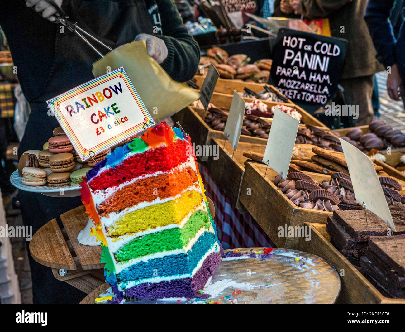 Mostra di torta Rainbow Layer che vende al mercato del cibo da asporto all'aperto in vendita al mercato del cibo di strada Covent Garden Piazza, stand Londra UK Foto Stock