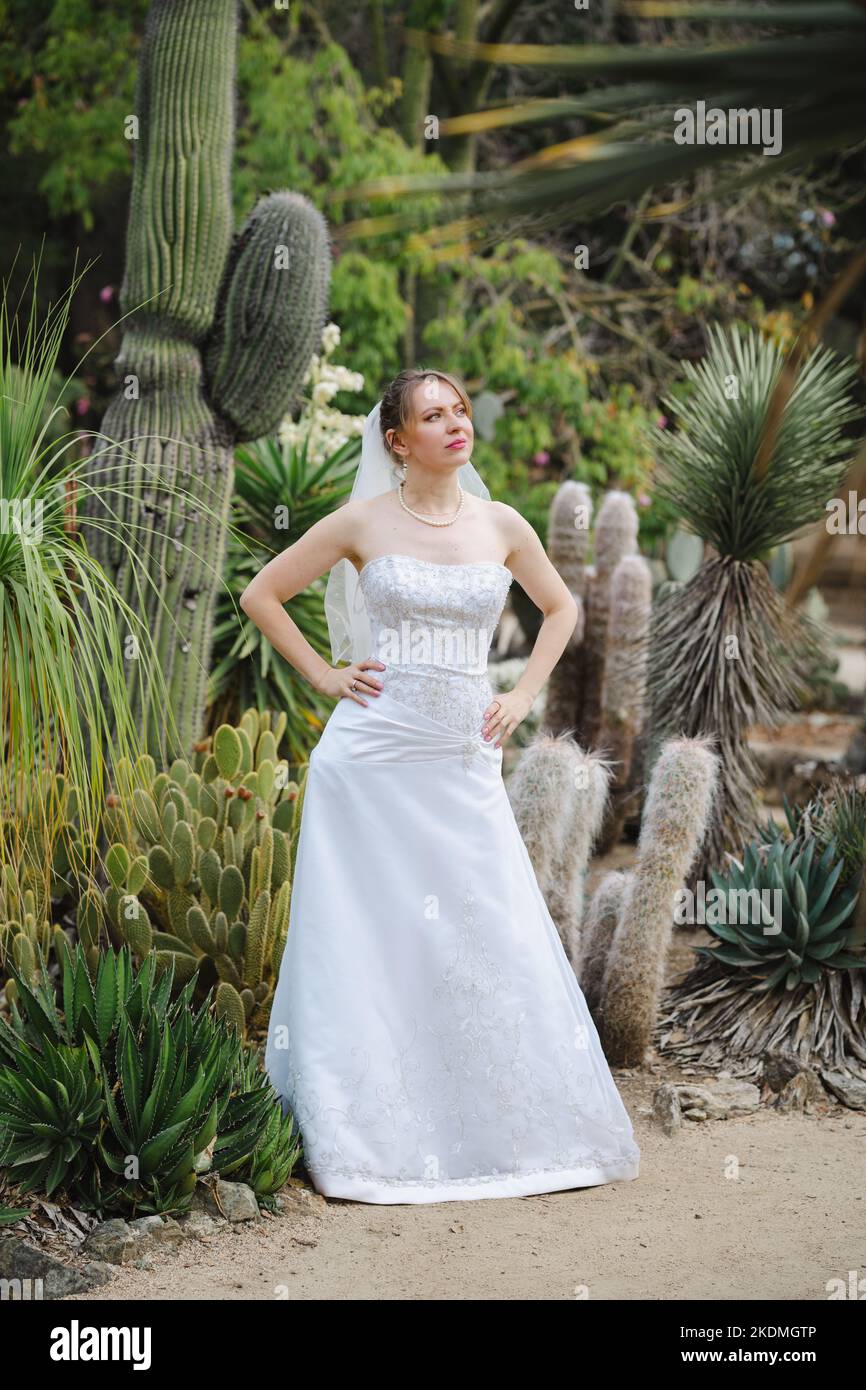 Sposa in piedi in un giardino di Cactus Foto Stock