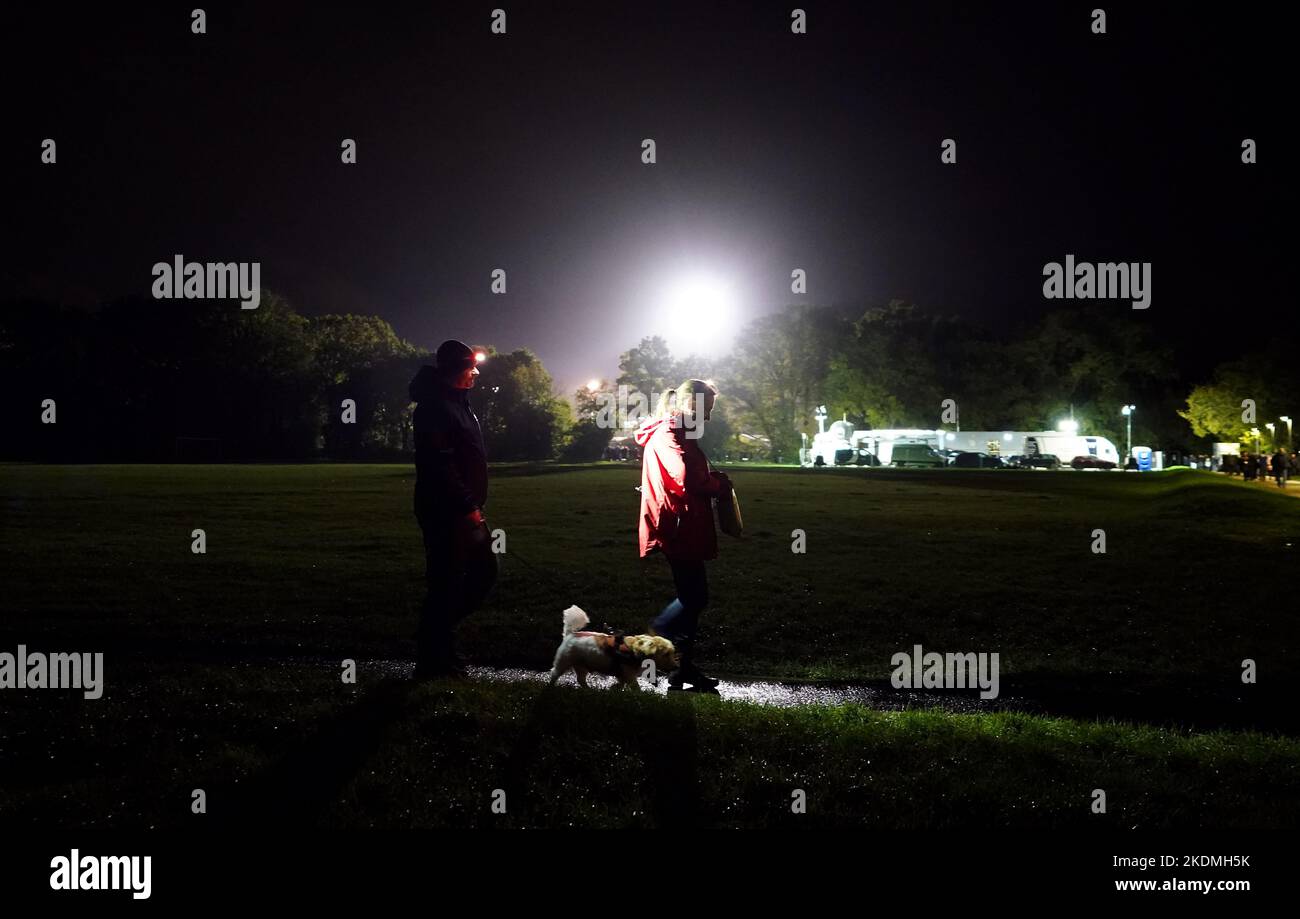 La gente cammina un cane fuori terra davanti alla partita di primo round della Emirates fa Cup allo stadio SB di Sandhurst. Data immagine: Lunedì 7 novembre 2022. Foto Stock