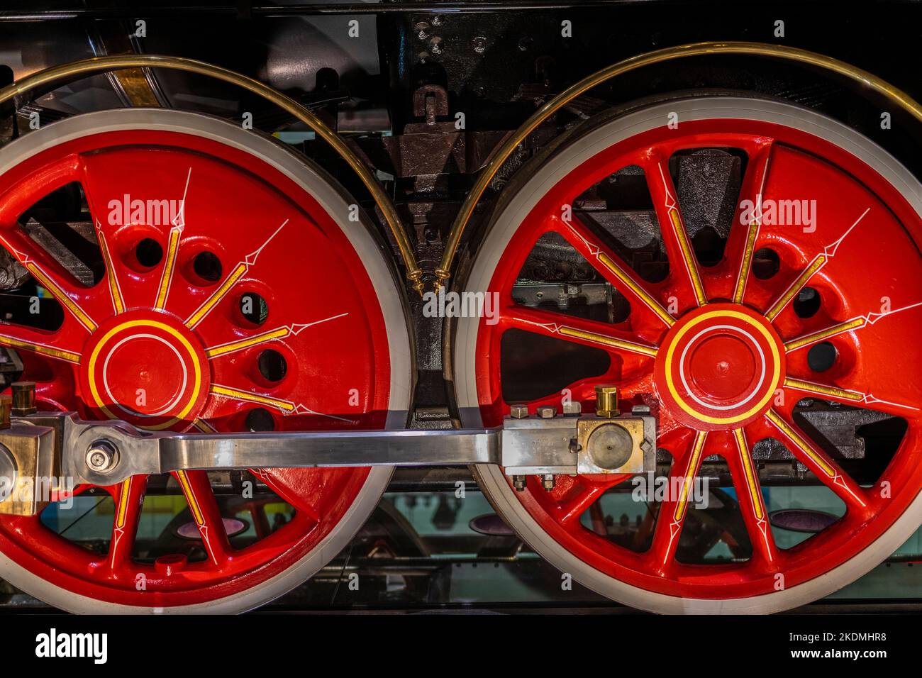 due ruote rosse e l'asta di accoppiamento su una locomotiva a vapore Foto Stock