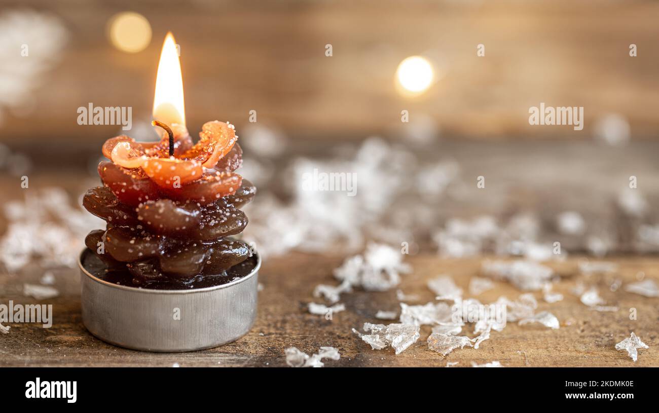 Sfondo di Natale con una candela bruciante a forma di cono. Foto Stock
