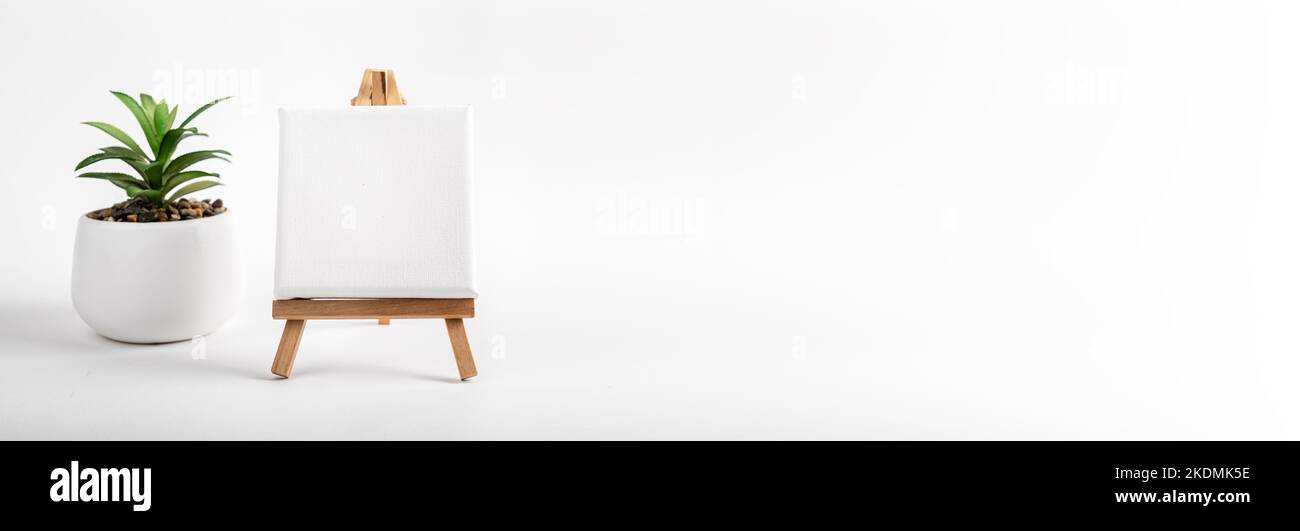 Tela quadrata bianca su cavalletto in legno, mockup e banner ad art con spazio copia. Foto di alta qualità Foto Stock