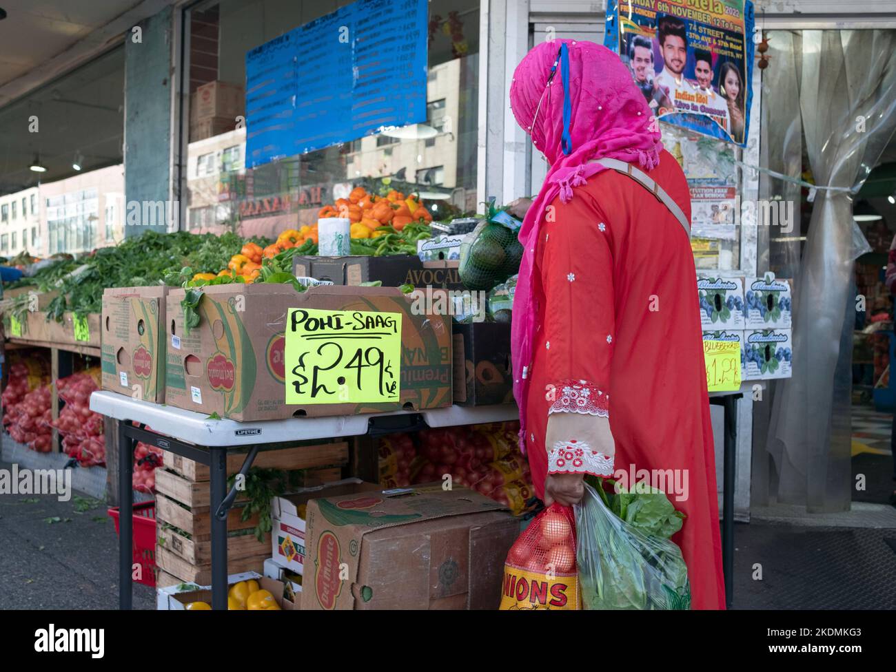 Una donna che indossa un hijab e negozi di maschere facciali per Pohi Saag vegetali al supermercato Apna sulla 37th Avenue a Jackson Heights, Queens, New York City. Foto Stock