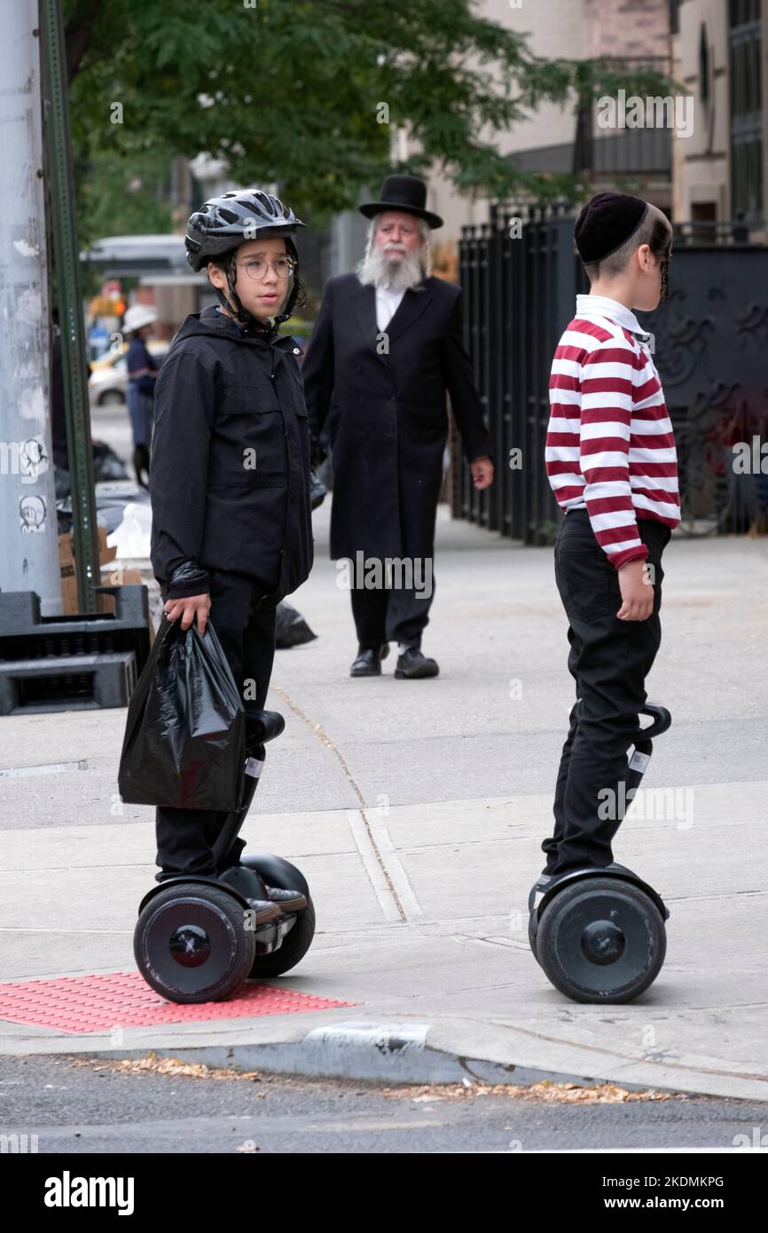 2 adolescenti ebrei ortodossi su hoverboard su Bedford Avenue a Brooklyn, New York. Foto Stock