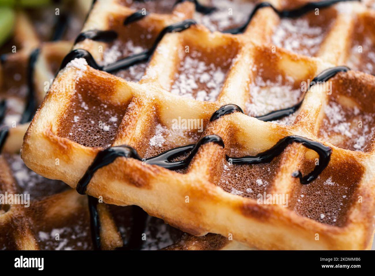 Primo piano, appetitosi waffle belgi sgocciciati con cioccolato. Foto Stock