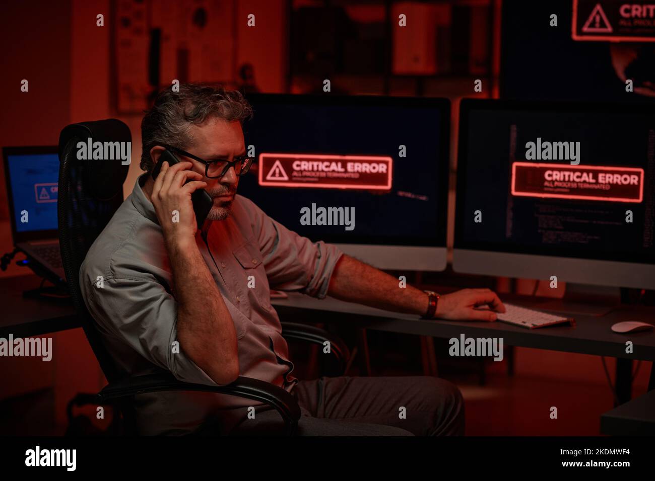 Programmatore serio o direttore di un grande e moderno REPARTO DI supporto IT o di un'azienda che parla con un telefono cellulare nella sala server Foto Stock