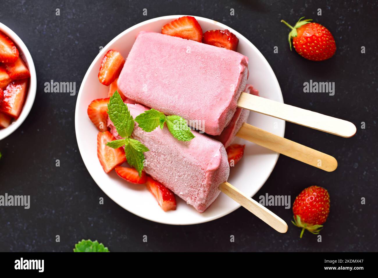 Popsicle di gelato alla fragola su piatto bianco. Vista dall'alto, disposizione piatta Foto Stock