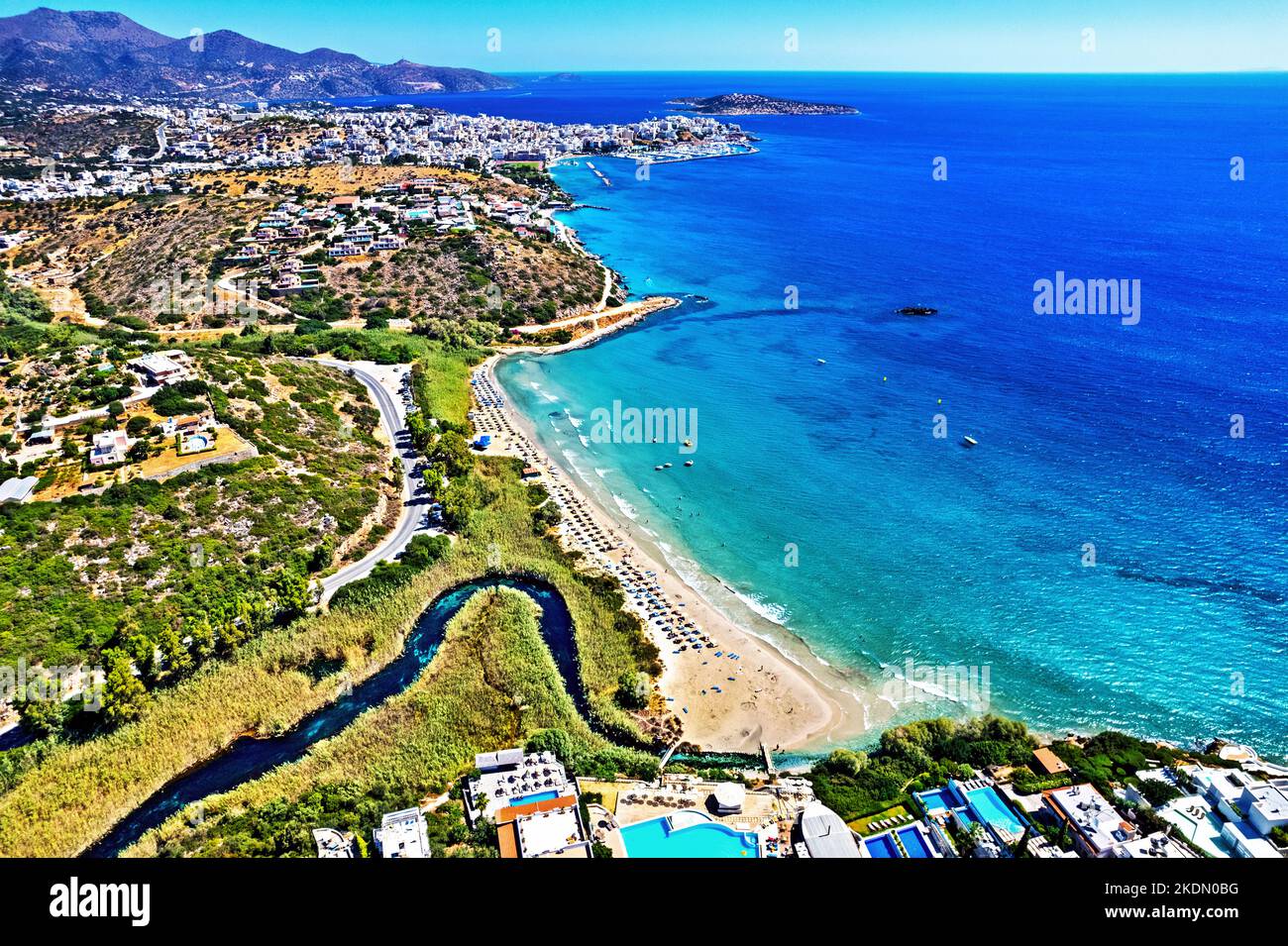 Vista aerea (drone) della spiaggia di Almyros (e zona umida) vicino alla città di Agios Nikolaos (sullo sfondo), prefettura di Lasithi, Creta, Grecia. Foto Stock