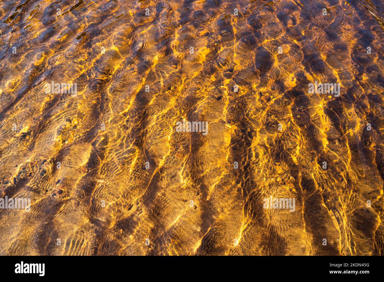 Una vista astratta sull'acqua marrone e sulla sabbia sotto di essa. Girato nel Parco Nazionale di Oulanka, Finlandia settentrionale. Foto Stock