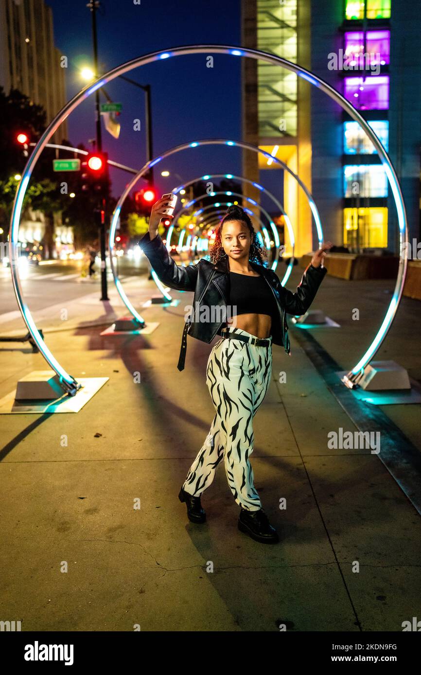 Giovane donna in illuminazione colorata al Sonic Walkway a San Jose Foto Stock