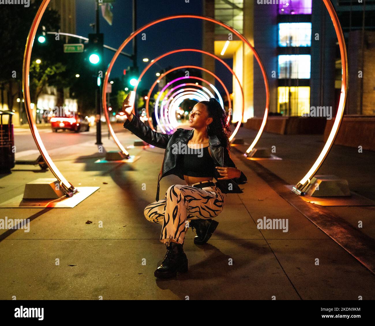 Giovane donna in illuminazione colorata al Sonic Walkway a San Jose Foto Stock