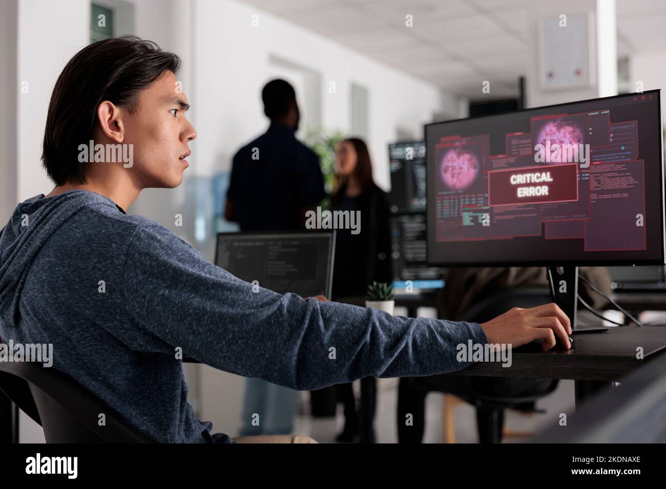 Preoccupato sviluppatore di software che ha violato il server Web, guardando l'errore critico sullo schermo del computer in ufficio programmazione. Sviluppatore Web asiatico cercando di risolvere il problema di hacking, firewall di sicurezza. Foto Stock