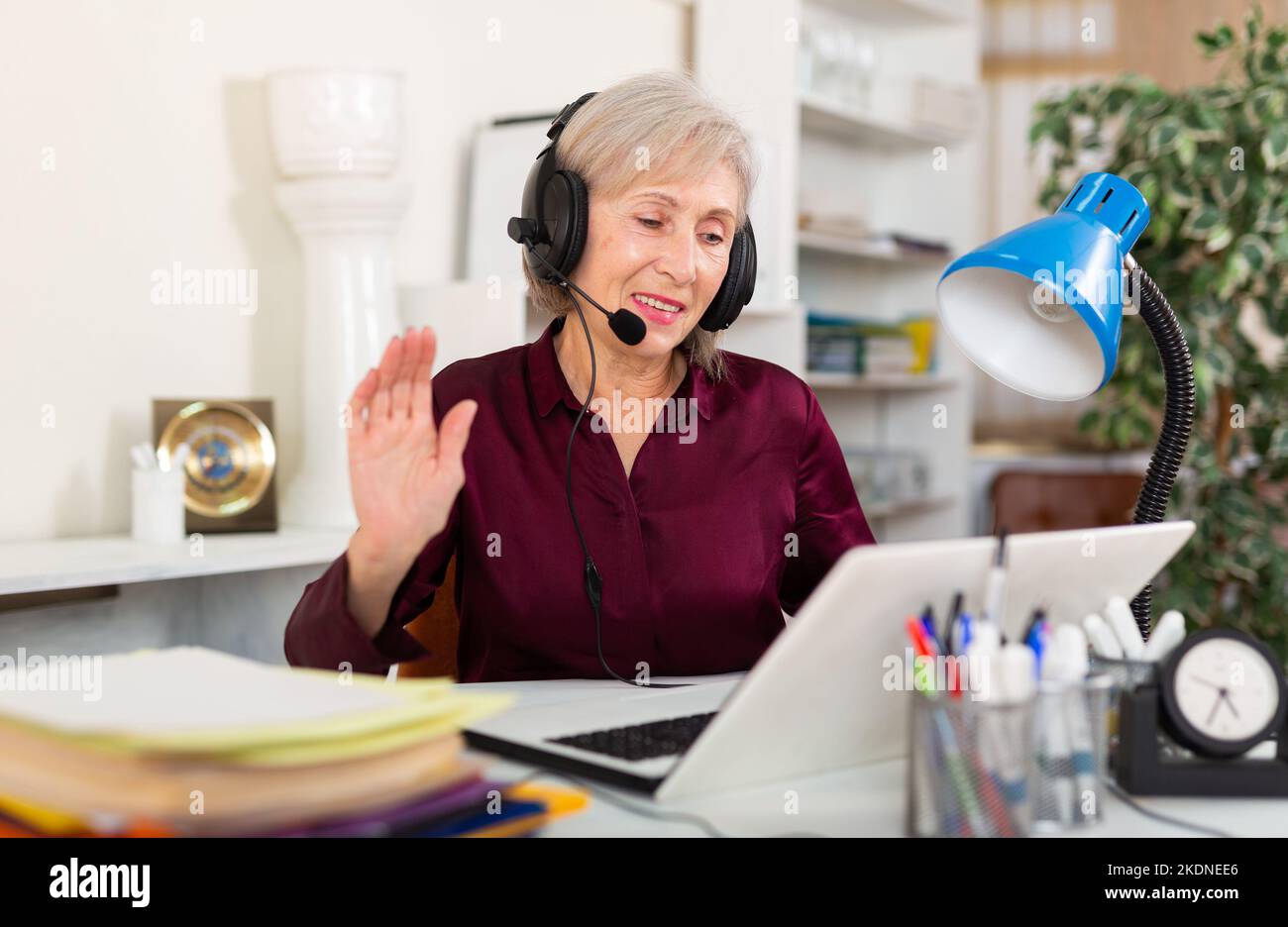 Donna in auricolari che lavorano in ufficio Foto Stock