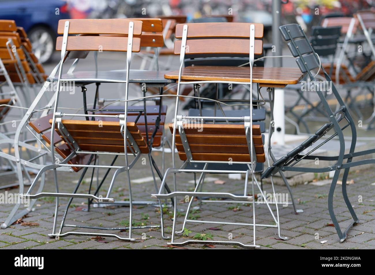 i tavoli e le sedie del catering esterno di un ristorante sul marciapiede sono fissati con funi metalliche Foto Stock
