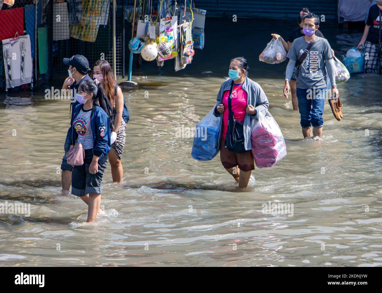 SAMUT PRAKAN, THAILANDIA, 29 2022 ottobre, le persone con l'acquisto sono a piedi attraverso la strada allagata Foto Stock