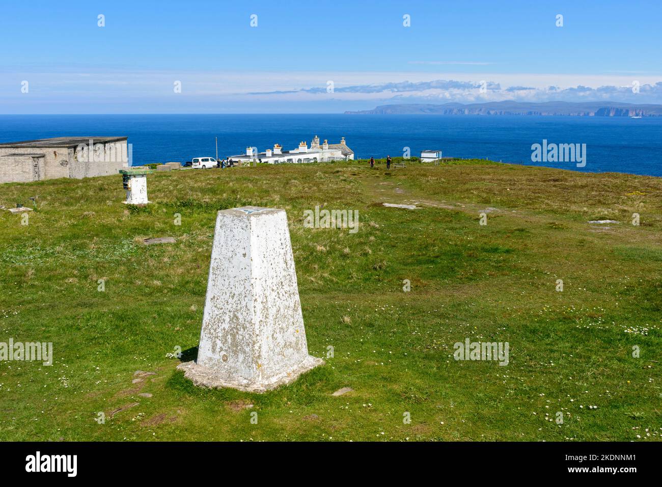 Il trig point alla cima di Dunnet Head, Caithness, Scozia, Regno Unito. In lontananza sono le colline di Hoy, Orcadi, sopra il Pentland Firth. Foto Stock