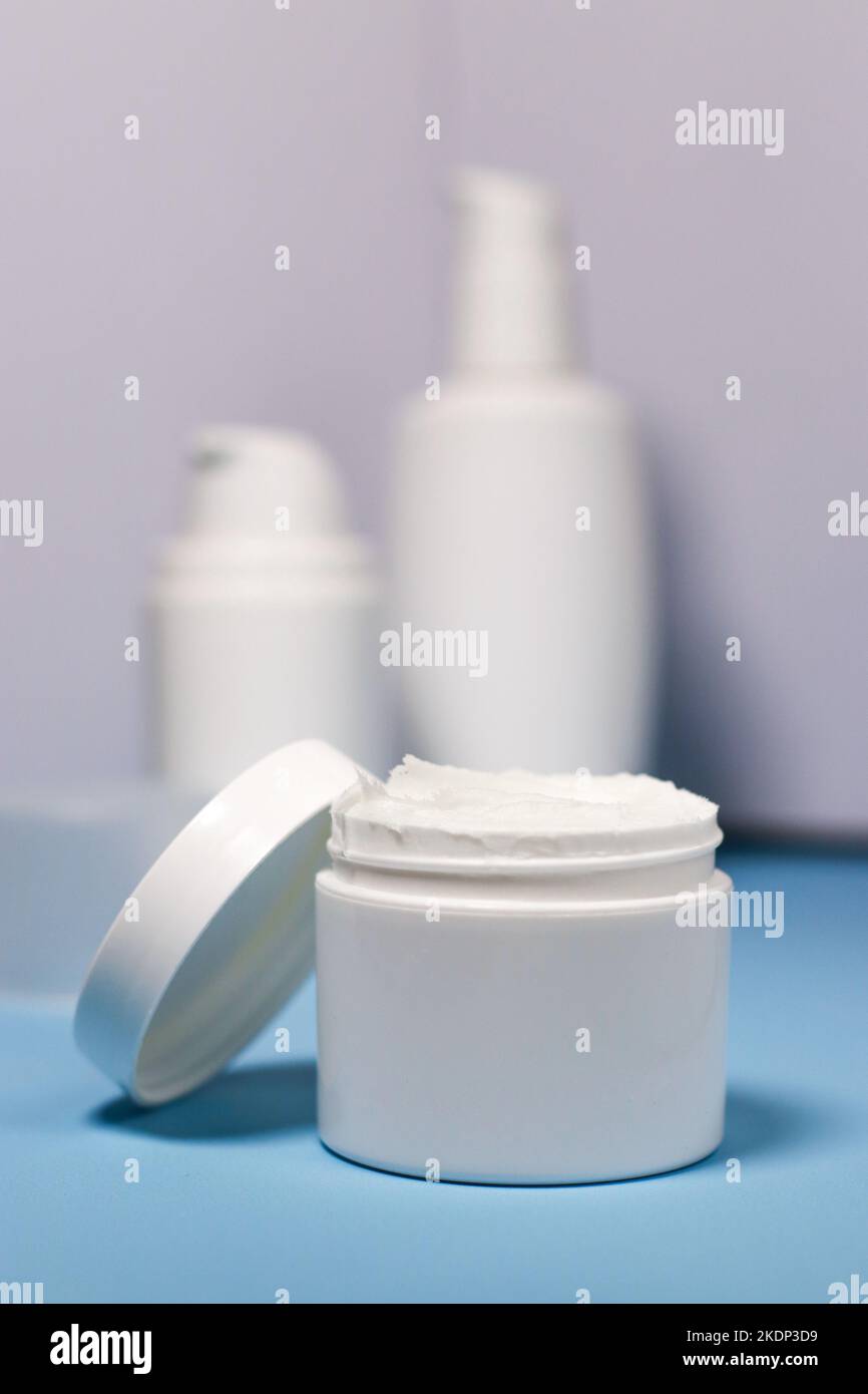 primo piano di un vaso bianco con crema su sfondo blu Foto Stock