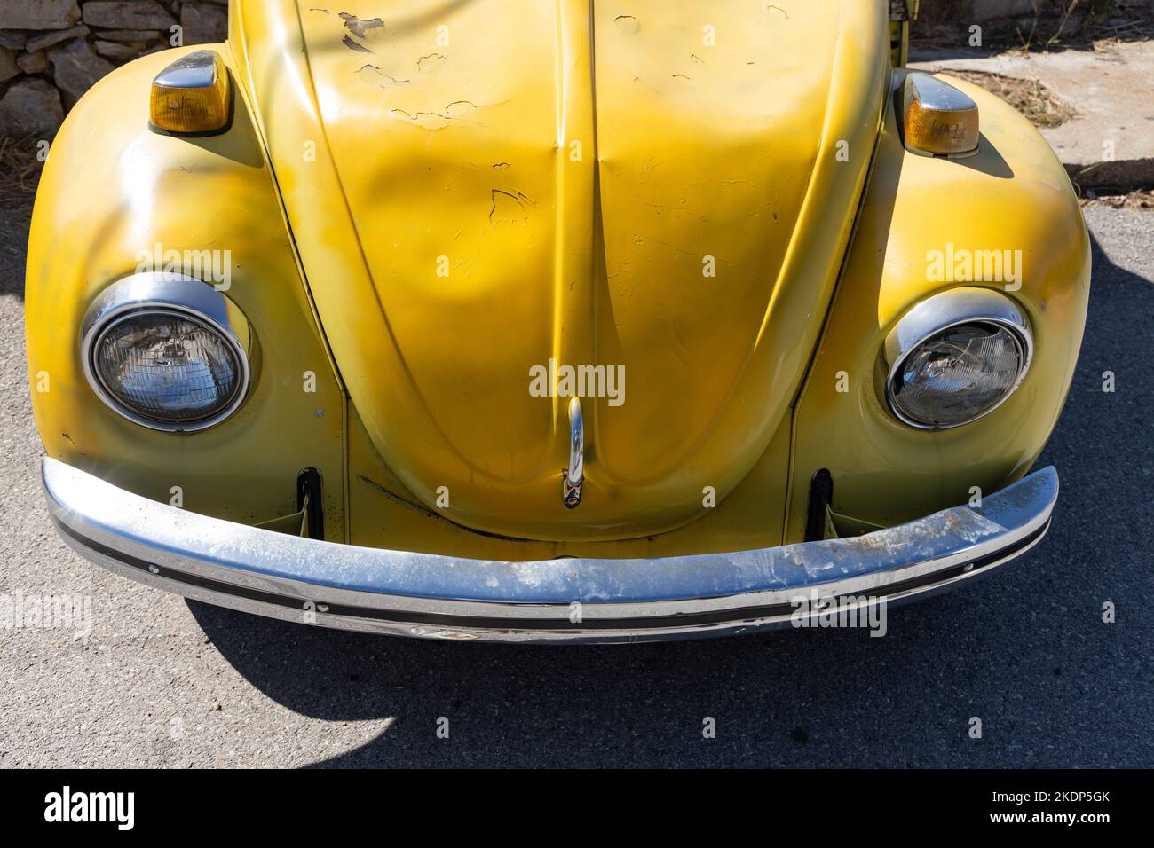 Vista frontale della vecchia auto arrugginita gialla abbandonata con graffi sul cofano. Foto Stock