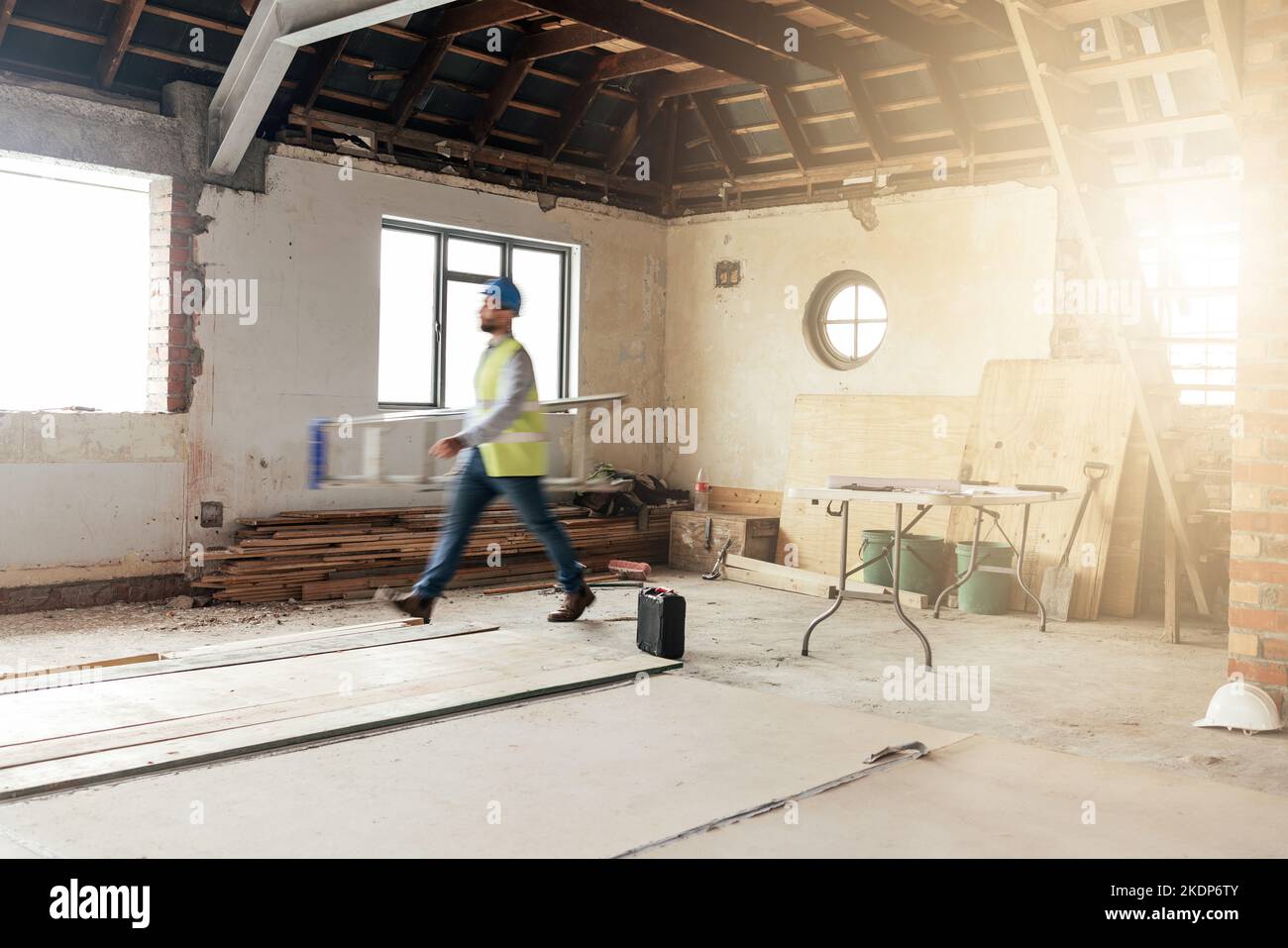 Costruzione, casa e appaltatore camminando in un edificio con manutenzione, ristrutturazione e lavoro con sole. Architettura, ristrutturazione casa e veloce Foto Stock