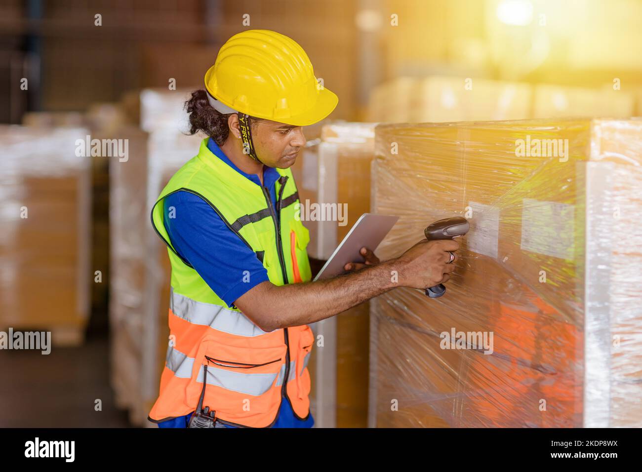 lavoratore indiano nel settore della logistica che lavora sistema di gestione dell'inventario utilizzando lettore di codici a barre e tablet computer Foto Stock