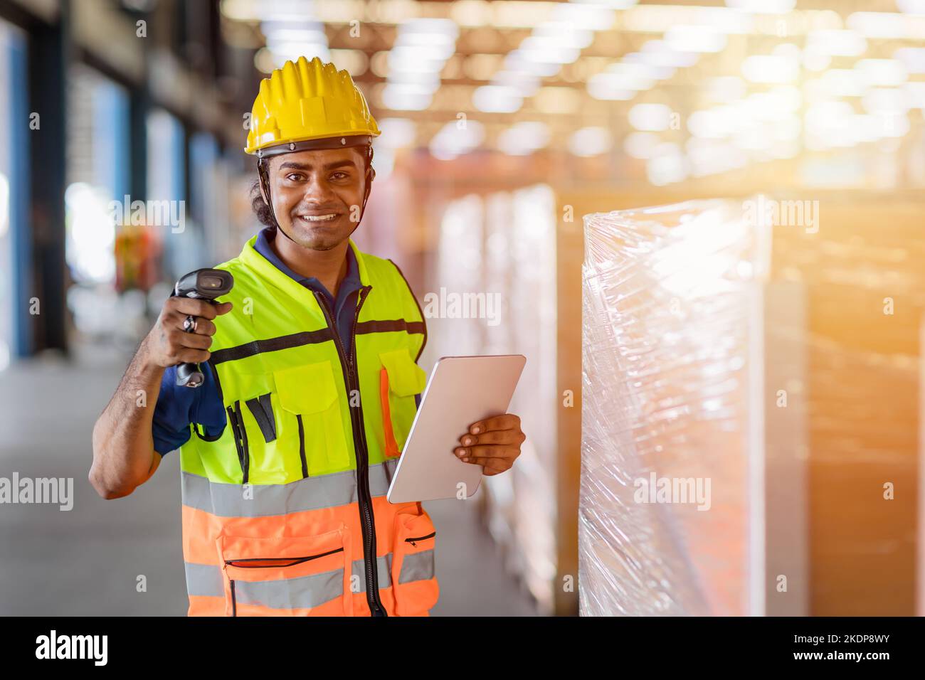 ritratto felice lavoratore indiano lavoro in magazzino come spedizione personale di controllo della scatola di carico Foto Stock