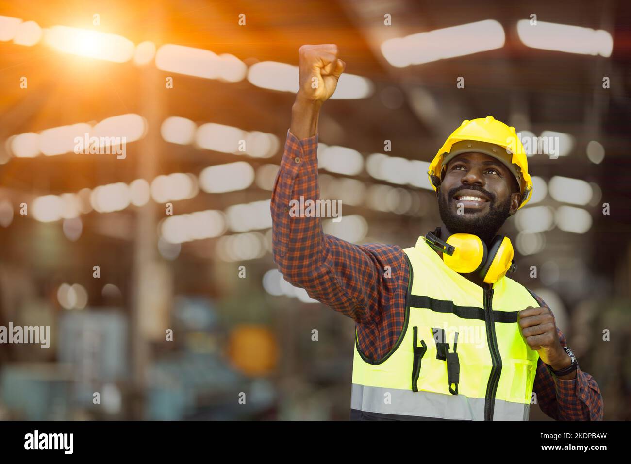 Successo nero africano maschio lavoratore sollevato il suo pugno in felice gioioso. Complimentarsi godere di lavorare e ricevere il buon concetto di benessere Foto Stock