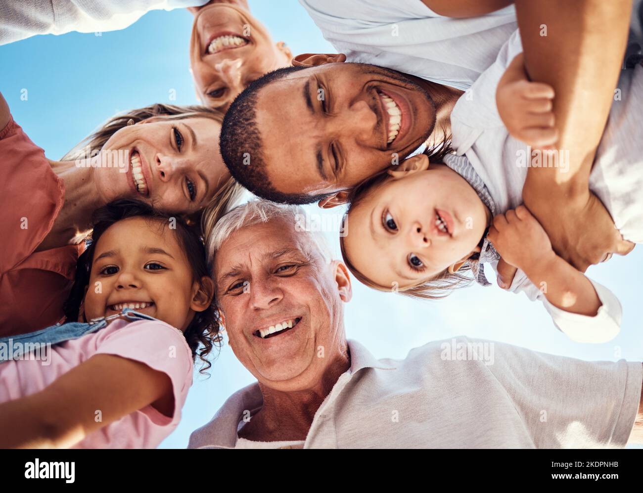 Diversità, huddle e famiglia con sorriso, felice e legame insieme per la vacanza, trascorrere tempo di qualità e gioioso. Interracial, nonni o genitori Foto Stock