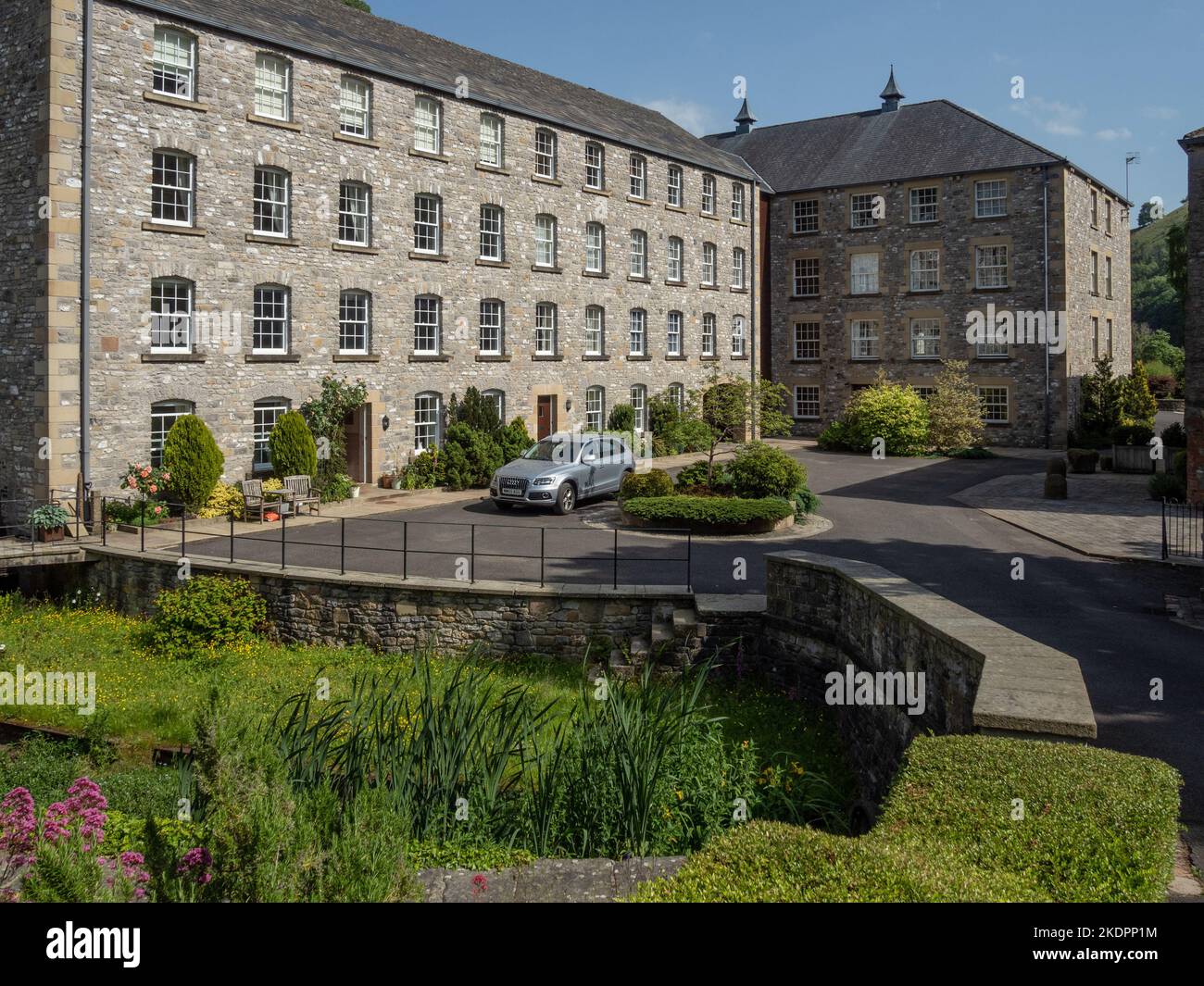 Cressbrook Mill, Peak District, Derbyshire; una vecchia filanda risalente al 1814 che è stato ristrutturato nel 2000 per uso residenziale. Foto Stock