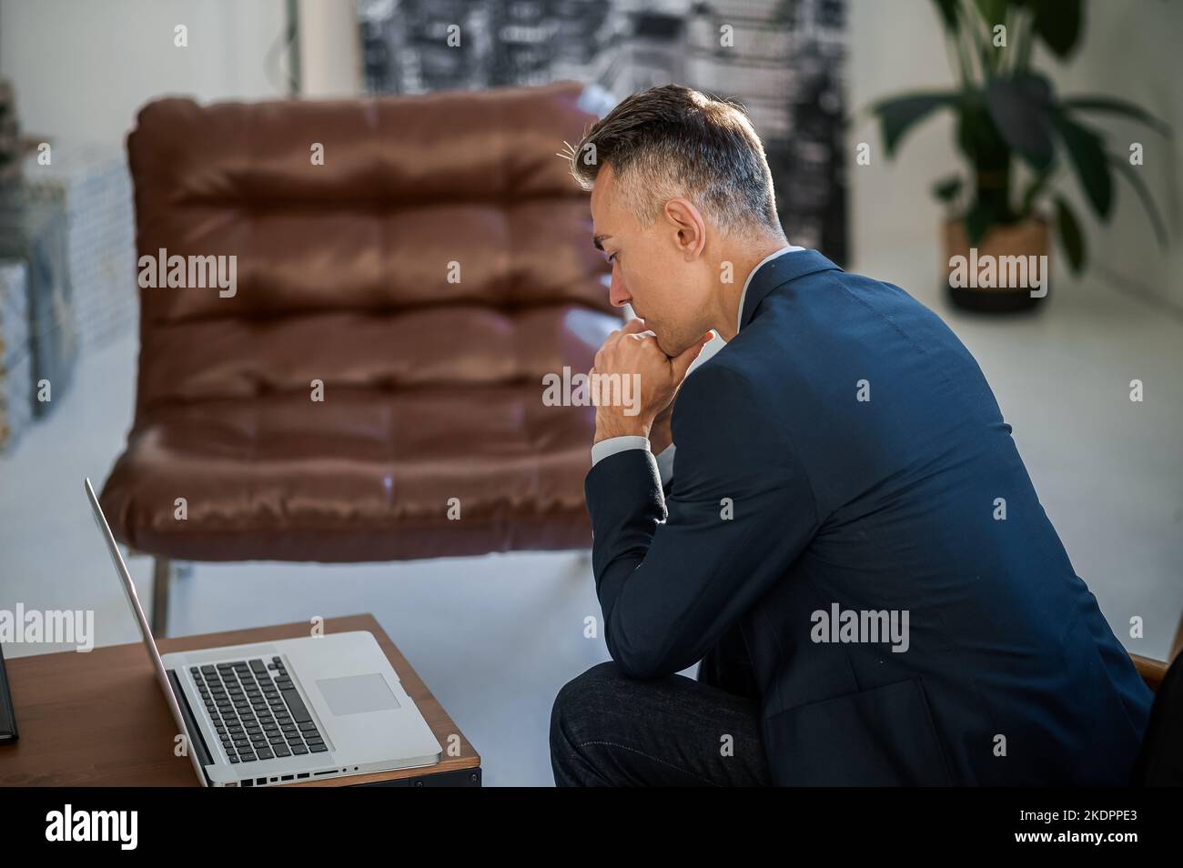 Uomo elegante e dall'aspetto buono in un abito che lavora in ufficio Foto Stock
