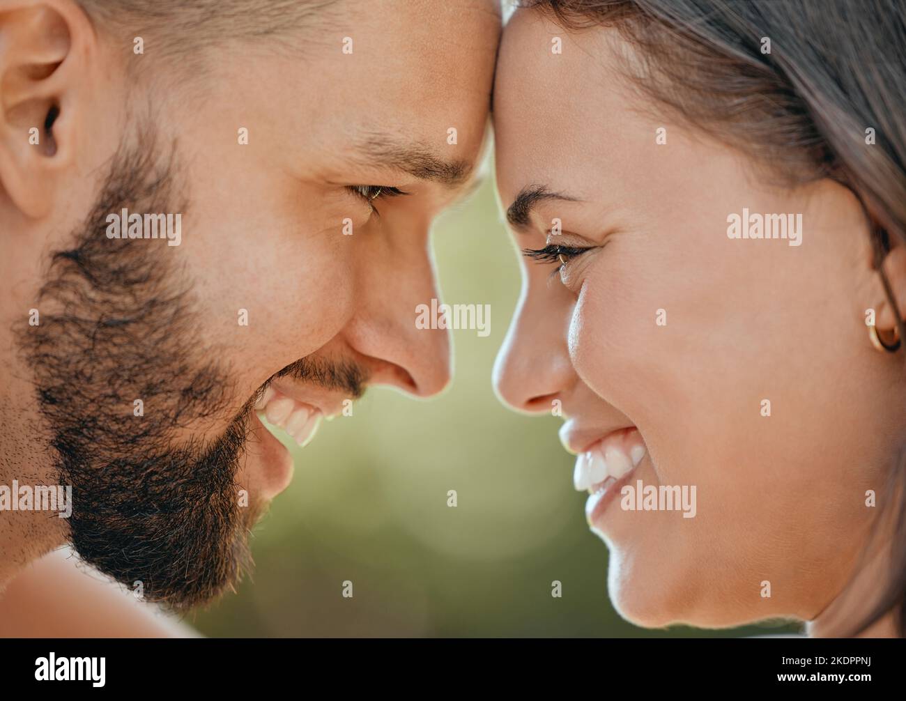 Faccia di coppia felice che tocca la testa nell'amore, nella cura e nella felicità in giardino, parco o natura primaverile all'aperto. Primo piano giovani, sorridere e felici, uomo Foto Stock