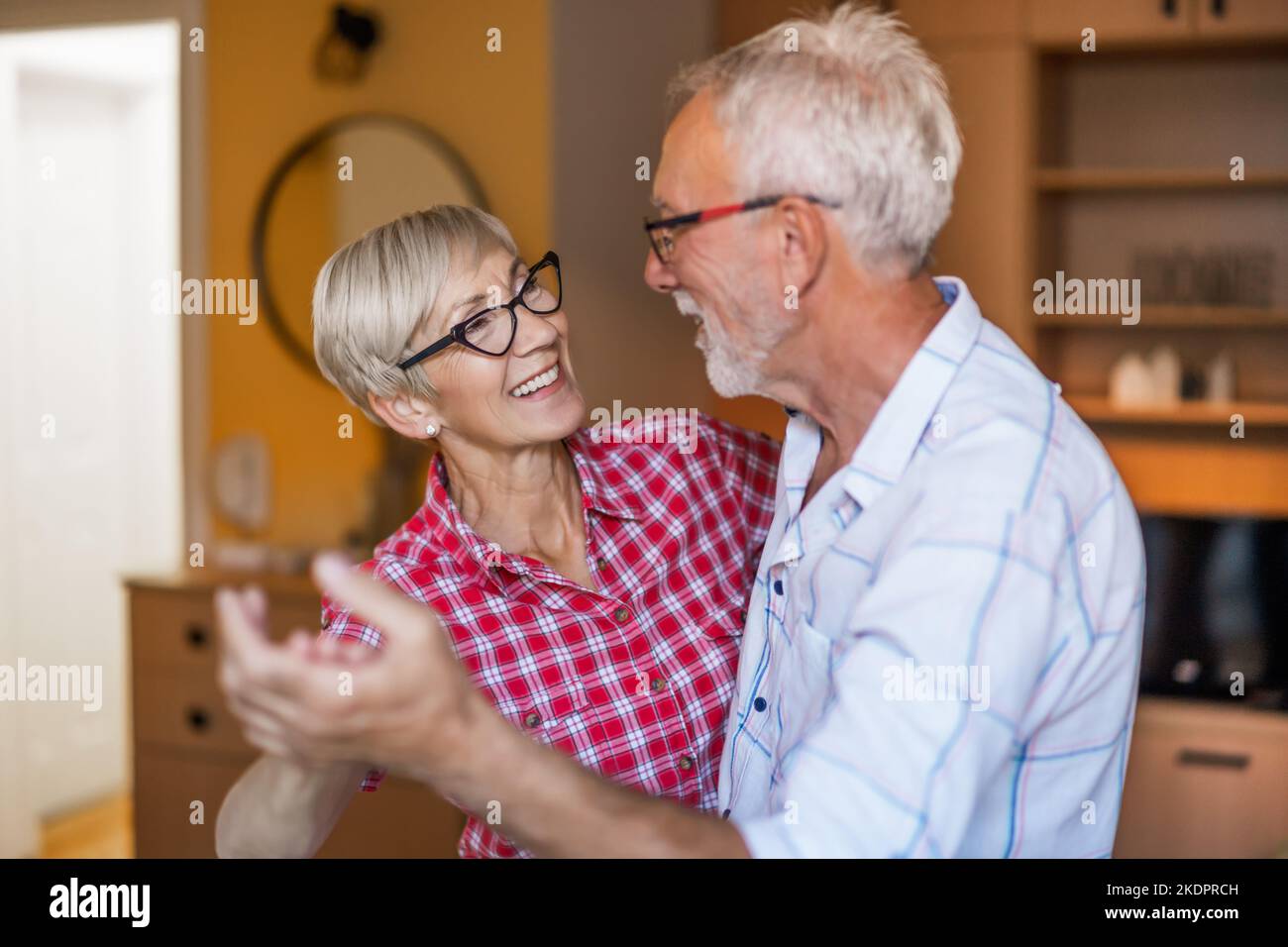 Felice coppia anziana sta ballando a casa. Anziani che hanno tempo piacevole insieme. Foto Stock