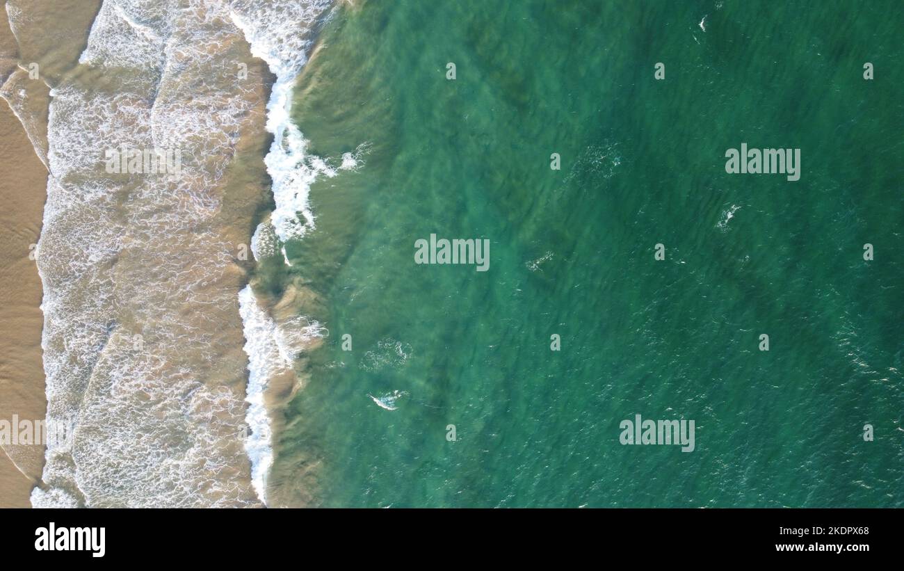 Vista aerea di un mare verde smeraldo e grandi onde schiumose. Oceano Indiano. Foto Stock