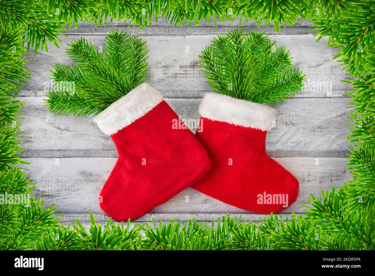 Decorazione di Natale e 2 Babbo Natale con rami di abete su sfondo in legno Foto Stock