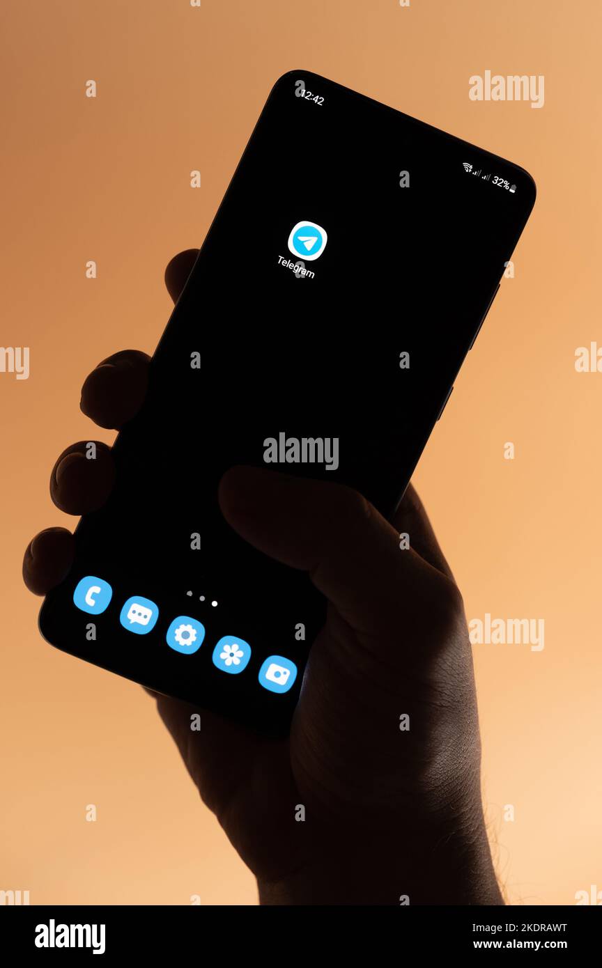 New york, USA - 4 novembre 2022: App per telegramma aperta su smartphone che tiene in mano isolato su sfondo marrone Foto Stock