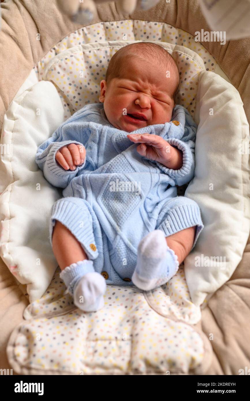 Bambino appena nato che piange in una sedia del bambino Foto Stock
