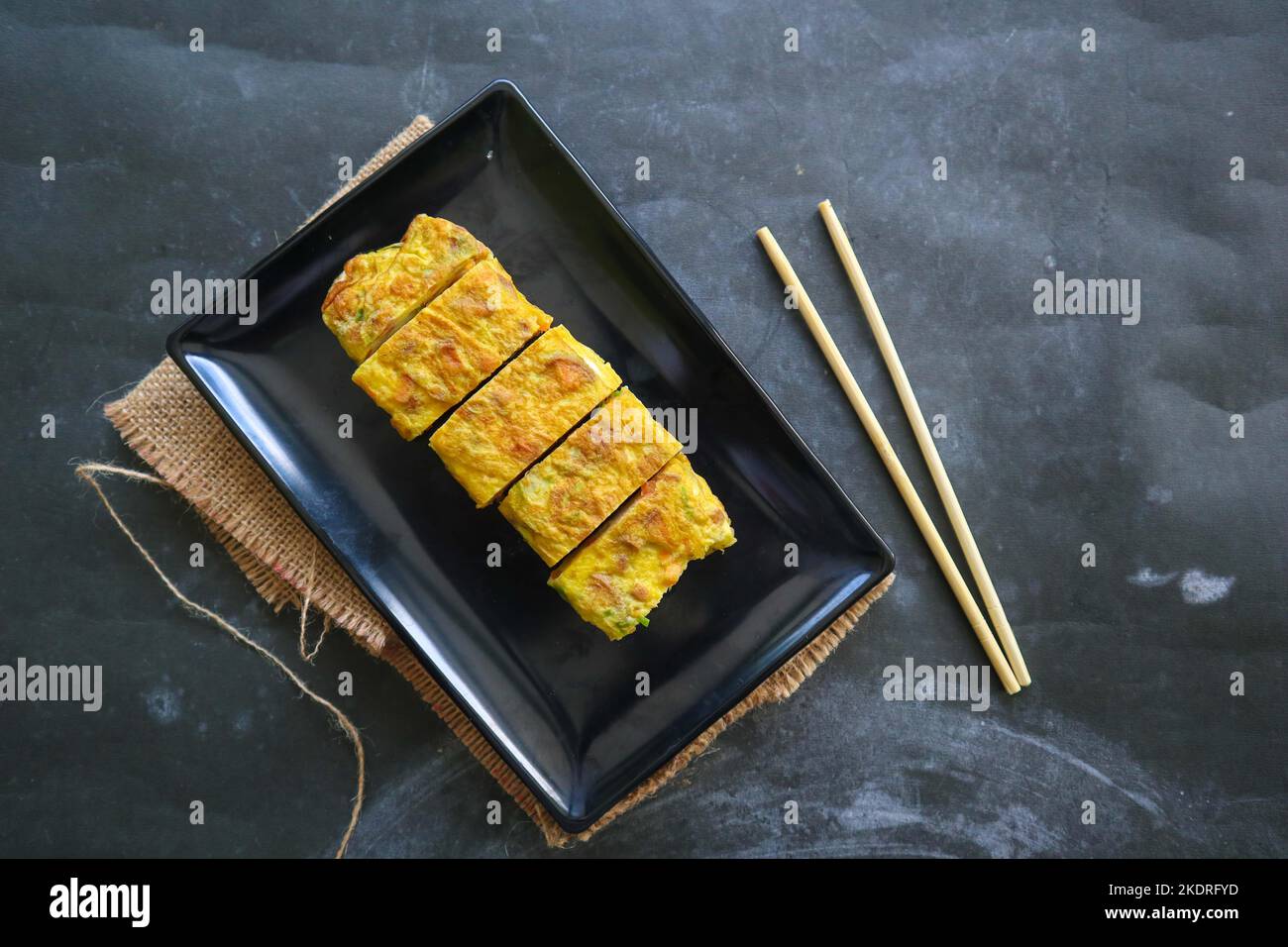 Telur dadar gulung o Tamagoyaki o Japaneses uovo rotolo. Gyeran Mari o Coreano arrotolato omelette. Uovo fritto Foto Stock