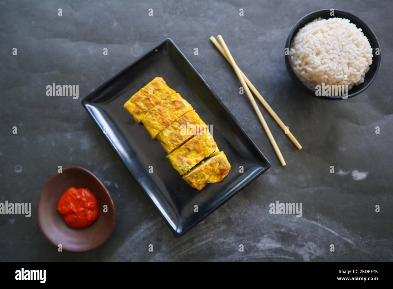 Telur dadar gulung o Tamagoyaki o Japaneses uovo rotolo. Gyeran Mari o Coreano arrotolato omelette. Uovo fritto Foto Stock