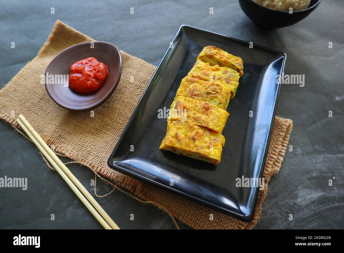 Telur dadar gulung o Tamagoyaki o Japaneses uovo rotolo. Gyeran Mari o Coreano arrotolato omelette. Uovo fritto Foto Stock