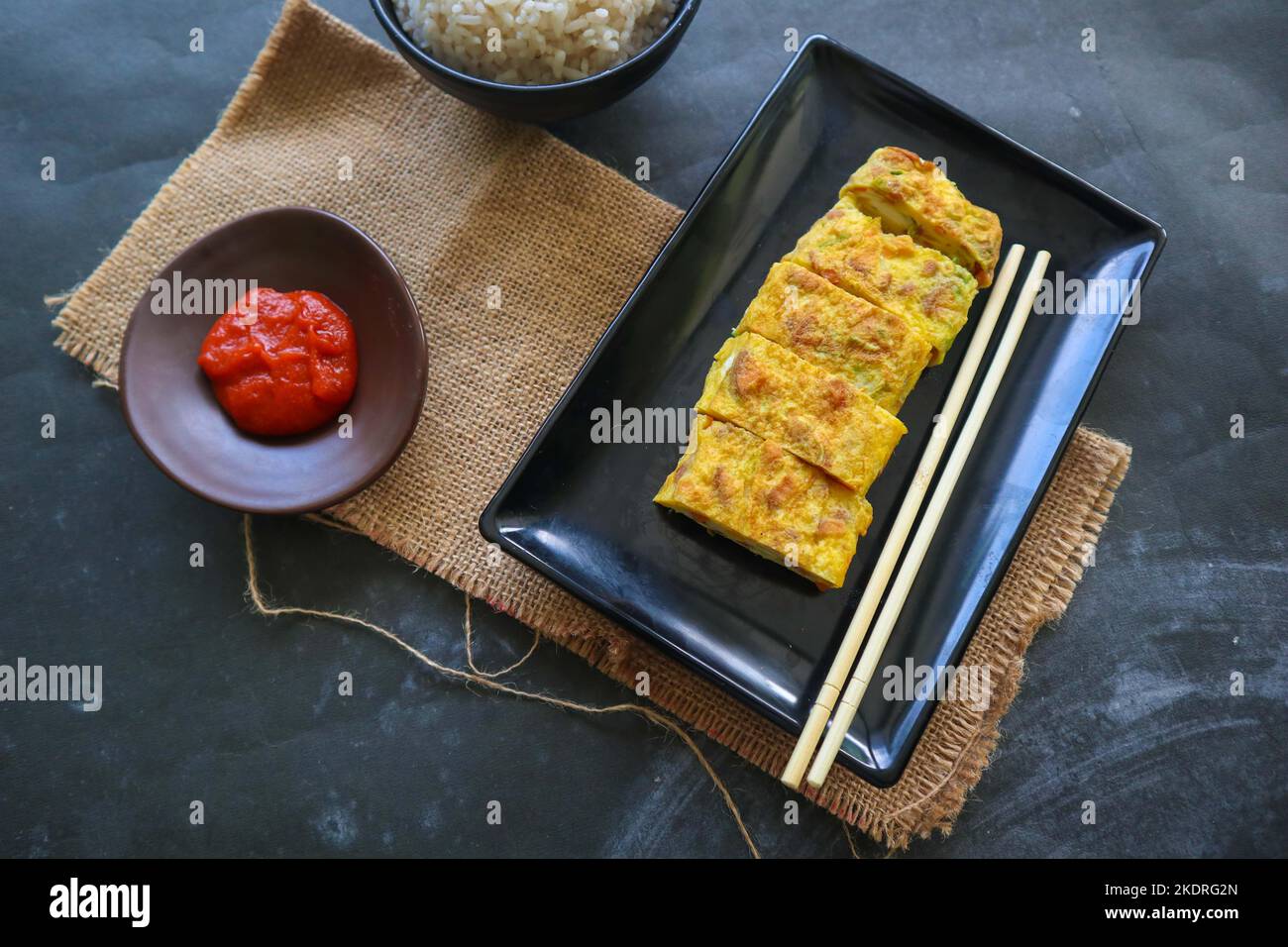 Telur dadar gulung o Tamagoyaki o Japaneses uovo rotolo. Gyeran Mari o Coreano arrotolato omelette. Uovo fritto Foto Stock