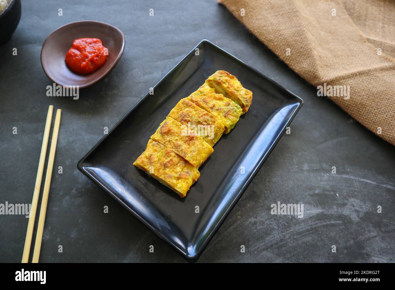 Telur dadar gulung o Tamagoyaki o Japaneses uovo rotolo. Gyeran Mari o Coreano arrotolato omelette. Uovo fritto Foto Stock