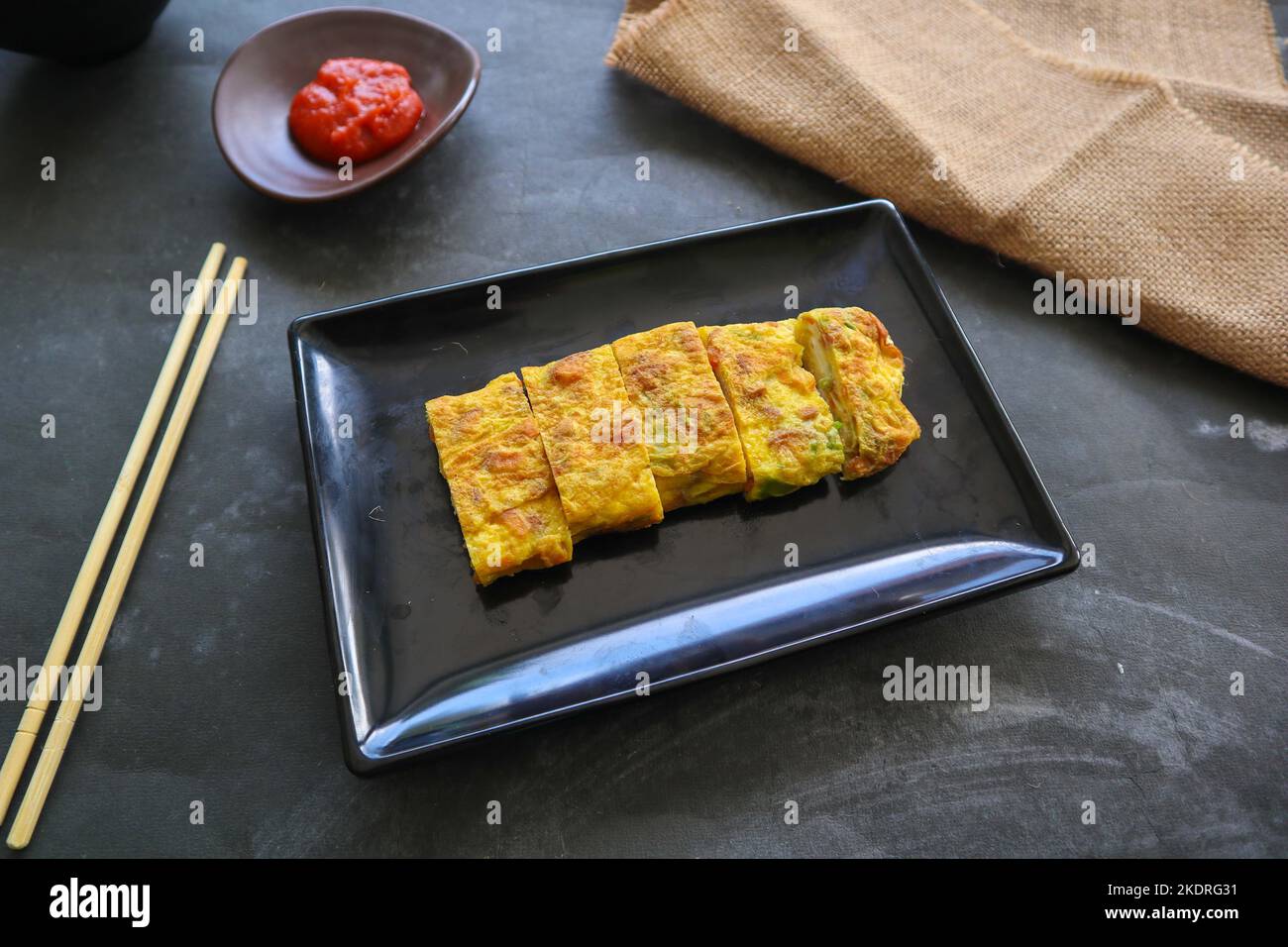 Telur dadar gulung o Tamagoyaki o Japaneses uovo rotolo. Gyeran Mari o Coreano arrotolato omelette. Uovo fritto Foto Stock