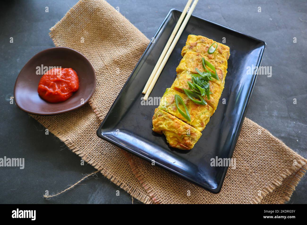 Telur dadar gulung o Tamagoyaki o Japaneses uovo rotolo. Gyeran Mari o Coreano arrotolato omelette. Uovo fritto Foto Stock