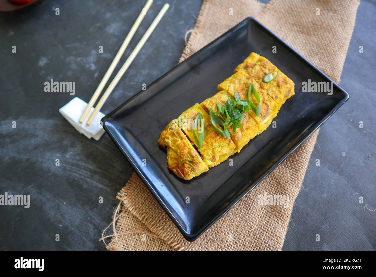 Telur dadar gulung o Tamagoyaki o Japaneses uovo rotolo. Gyeran Mari o Coreano arrotolato omelette. Uovo fritto Foto Stock