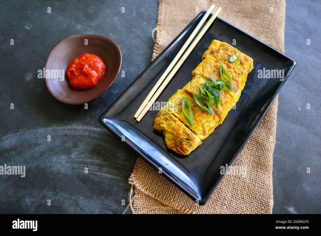 Telur dadar gulung o Tamagoyaki o Japaneses uovo rotolo. Gyeran Mari o Coreano arrotolato omelette. Uovo fritto Foto Stock