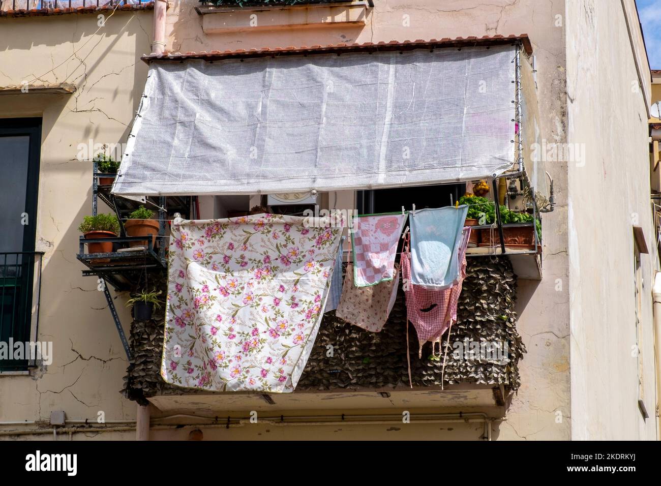 Immagine di un asciugabiancheria sul balcone di un appartamento italiano che si trova vicino ai binari del treno ma senza giardino. Foto Stock