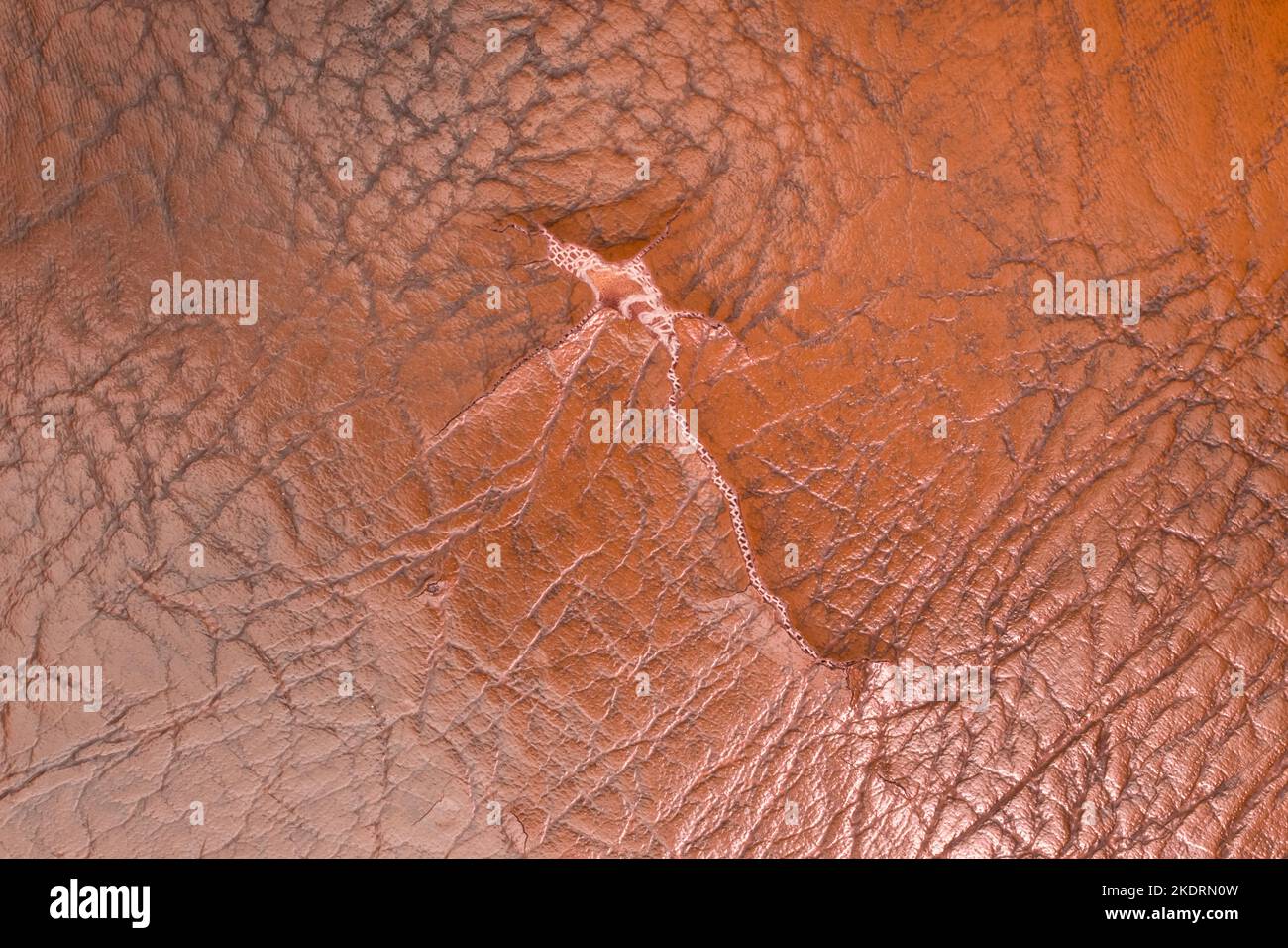 Tessuto strappato colore arancione marrone materiale vecchio tessuto tela vintage pelle. Foto Stock